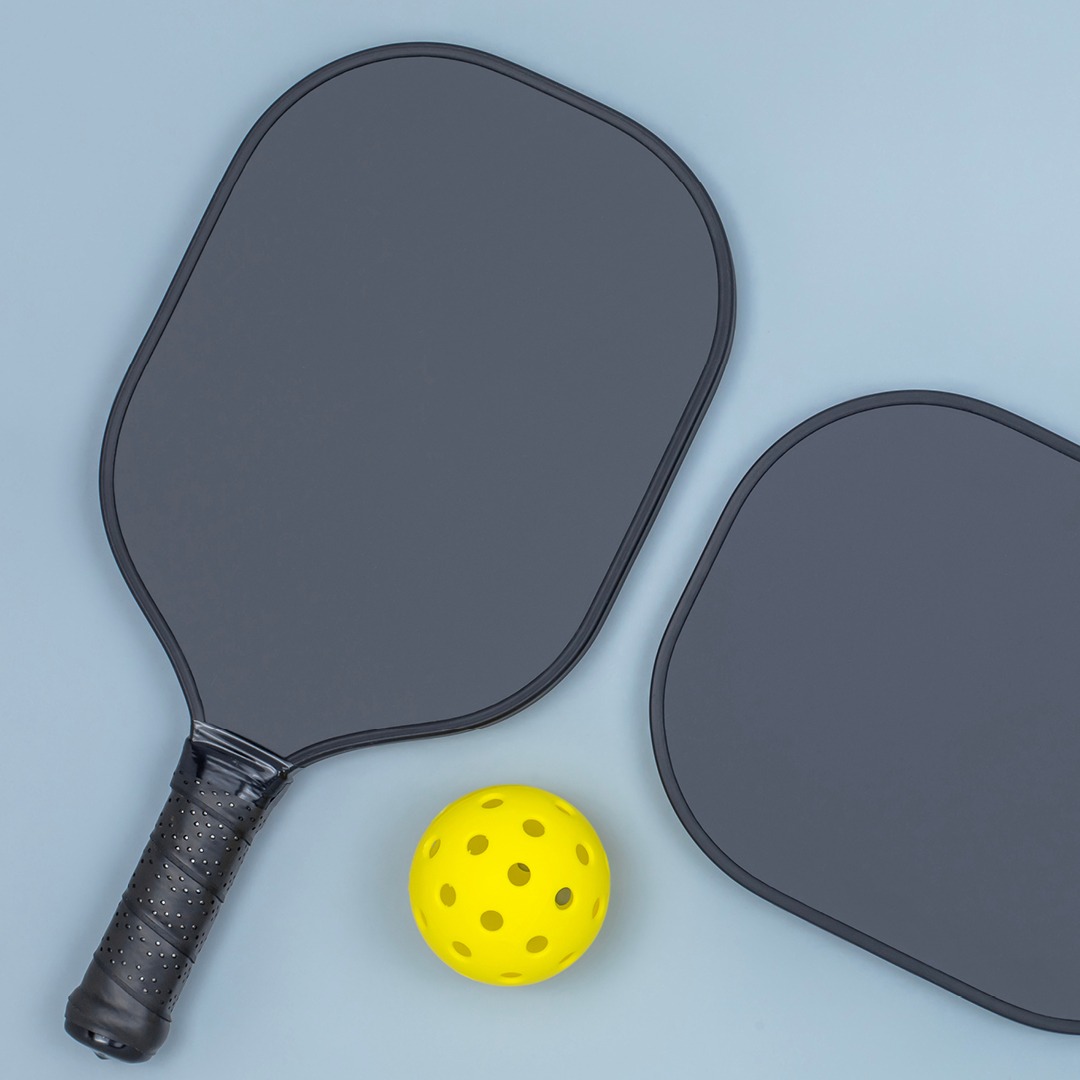 Two pickleball racquets and pickleball